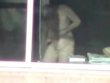 Sea woman getting dressed in window voyeur