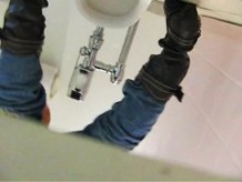 Girl in jeans and boots pissing on toilet shot from behind