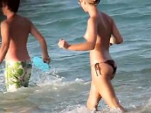 Topless girl playing on the beach and getting voyeured
