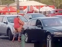 Boy with girl having sex on a car in the bazaar.