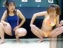 Desesperadas muñecas japonesas en traje de baño meando en el piso