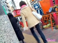 Chica asiática se tiró la falda en su bicicleta con gente cerca