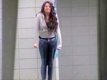 Chica desesperada mojando sus jeans en la calle
