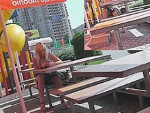 Sexy sentada bajo la falda en un café de la calle
