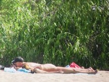 Cazador nudista en la playa voyeuring cuerpos desnudos detrás de los arbustos
