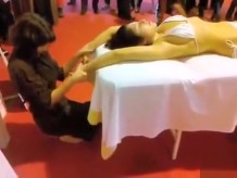 Doble masaje en público de una chica asiática en bikini
