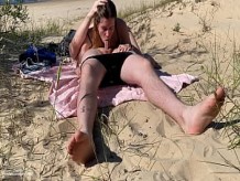 Pareja nudista disfrutando de una mamada en la playa pública