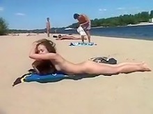 Adolescente delgada con tetas turgentes desnuda en la playa