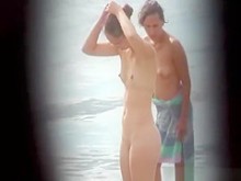 Nerd nudista desnudo en la playa