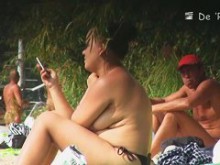 filma mujeres nudistas en la playa bronceándose sus cuerpos y sus grandes tetas