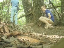 Un chico se pone en guardia mientras su novia orina detrás de un árbol
