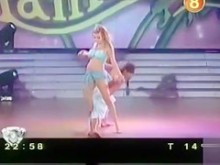 Chica de falda corta baila en la televisión y muestra el botín