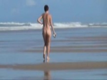 Vieja novia caminando desnuda en la playa