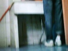 La linda perra se está orinando en el pequeño agujero del inodoro