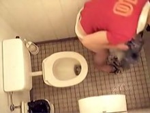 La chica desnuda se está orinando en el inodoro