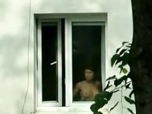 La morena desnuda se espía en la ventana