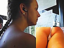 Adolescente de edad legal con auriculares en las piernas bajo la enagua (18+)