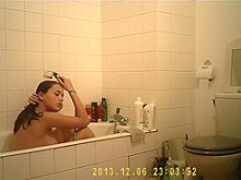 Cutie morena disfruta de una ducha caliente en el baño