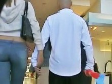 Chica alta y sexy en jeans mostrando su trasero para la cámara sincera