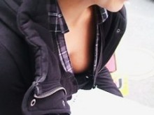 Una chica asiática caliente con blusa baja mostrando un pezón duro en sujetador negro