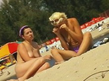 Dos chicas en topless tomando el sol frente a una