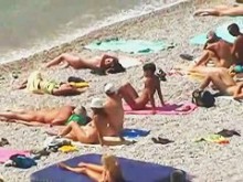 Hombres musculosos y mujeres elegantes en un vídeo sincero en una playa nudista