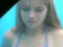 Linda adolescente poniéndose un bikini azul (18+)