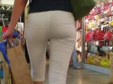 Chica caliente con pantalones ajustados y blancos en un vídeo de supermercado